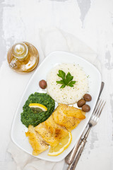 fried cod fish with spinach and rice on dish