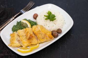 fried cod fish with spinach and rice on dish