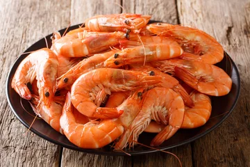 Tuinposter Healthy diet food: boiled wild tiger shrimps close-up on a plate on a table. horizontal © FomaA