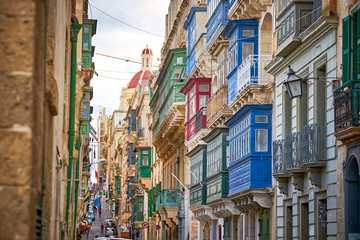 Street in Valetta city with a lot of traditional colorful balconies