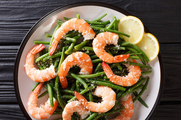 King prawns with green beans, cheese and lemon close-up on a plate. horizontal top view from above