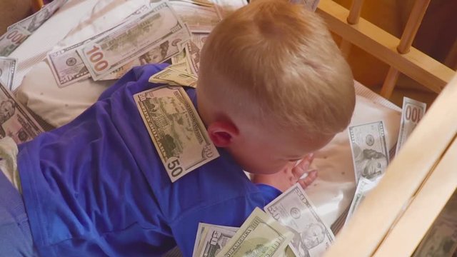 sleeping baby and falling money. Concept unexpected wealth.
