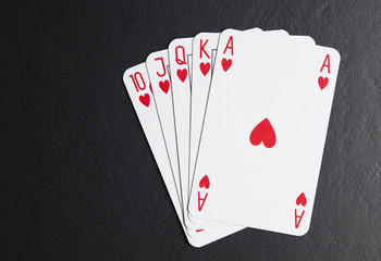 Royal flush in hearts on a black background
