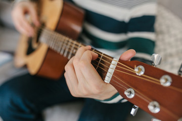 Obraz premium Learning to play the guitar. Music education and extracurricular lessons.