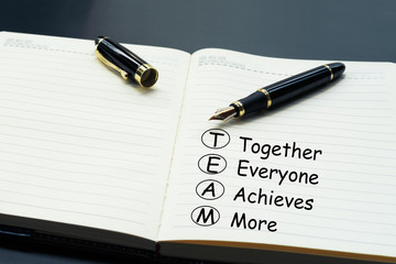 Teamwork concept. luxury pen writing word Teamwork, Together, Everyone, Achieves and More on the daily notebook