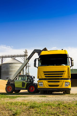 front end loader of grain from a pile to a truck