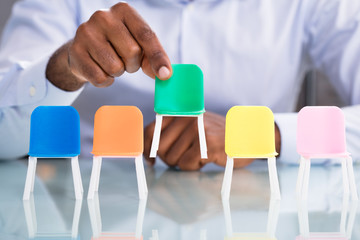 Businessman Holding Green Chair