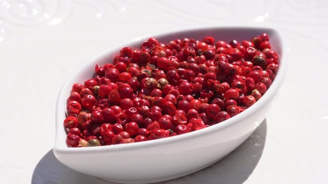 Dry spices pink pepper on a rotary table. 4K. Macroshooting.