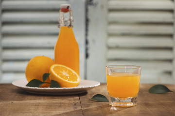 glass of orange juice with fresh fruits on wooden background