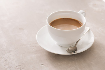 White china cup of tea with milk on a plain background