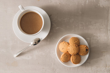 White cup of creamy coffee with butter cookies and stainless teaspoon isolated on white background, clipping path