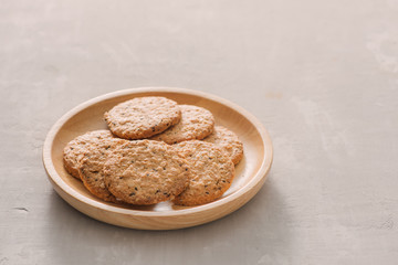 Oat cookies in plate isolated on white background, top view. Sweet bakery products. Round cookies in a wooden plate.