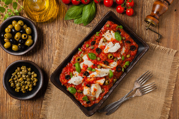 Cod in Italian in tomatoes with olives and capers.