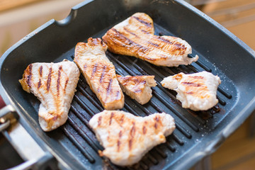 Sliced turkey fillet grilled in a frying pan. Fried meat without butter.