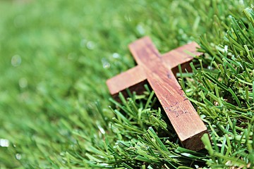 Blurred image. Christian crosses made of wood on a green background.