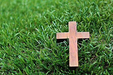 Blurred image. Christian crosses made of wood on a green background.