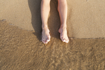 Female legs on sand
