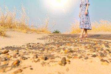 bare foot unhappy woman walk on the rock sand road alone