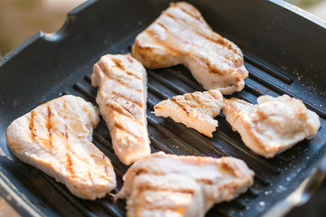 Sliced turkey fillet grilled in a frying pan. Fried meat without butter.