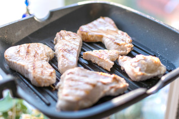 Sliced turkey fillet grilled in a frying pan. Fried meat without butter.