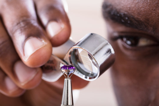Jeweler Examining Diamond Through Loupe - Powered by Adobe
