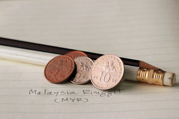 Ten sen Malaysia ringgit coin on reverse , Line image of Hibiscus rosa-sinensis and five sen with two coins of one sen, (MYR) with black and white pencil on the book. © Achisatha