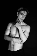 Fototapeta premium Portrait of fashion young caucasian sexy muscled attractive handsome athletic man boy model isolated on black background