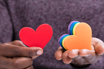 Fototapeta premium Person Choosing Red Heart From Colorful Hearts