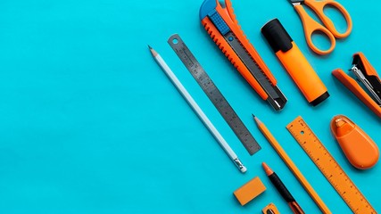 Group of stationery on blue color paper, flat lay picture.