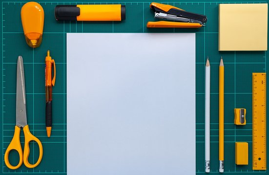 Flat lay picture of stationery and paper on cutting mat