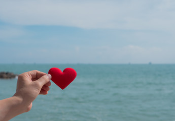 Fototapeta premium Hand with heart red shape and sea .