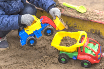 Children in warm winter clothes play in the sandbox close-up