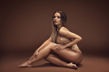 Obraz premium Sensual brunette woman with ideal tan body.
