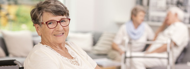 Panorama of happy elderly woman in the nursing house
