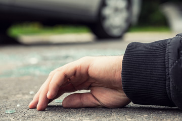 Close-up of a hand of dead person after collision with a car on the road