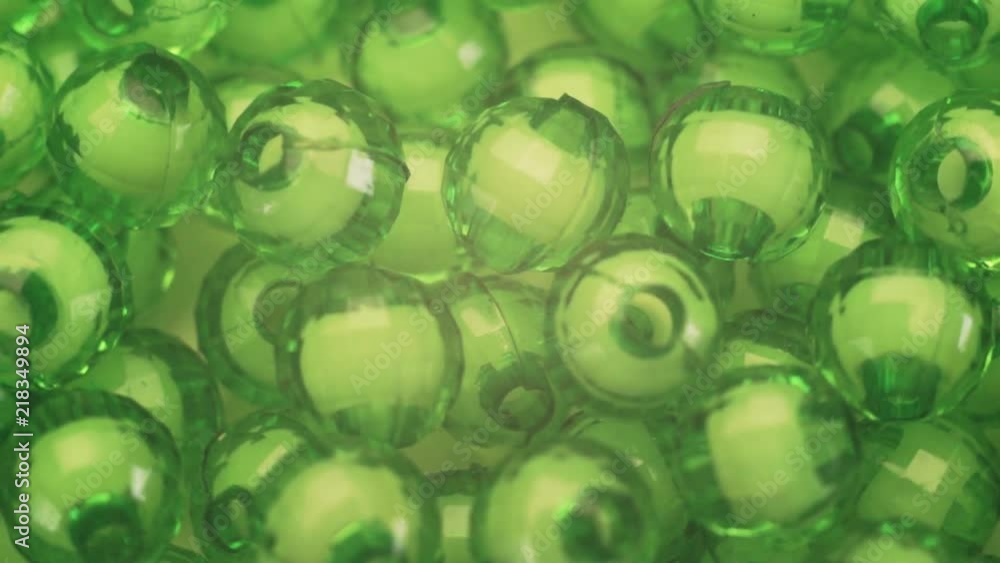Poster green beads rotation background. macro view.
