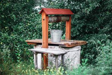 Old water well in the garden. Vintage draw well in european village