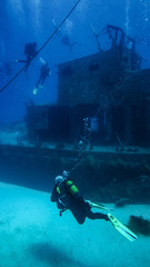 A scuba diver swims towards a wreck.