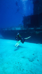 A diver swims towards a wreck