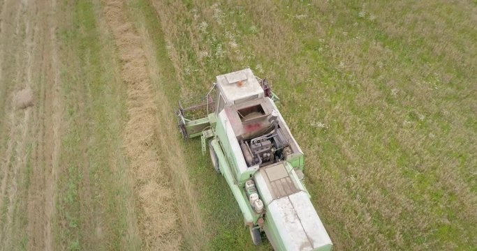 Aerial shot: An old chap combine harvester collecting ripe wheat