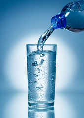 Pouring soda water from bottle into glass