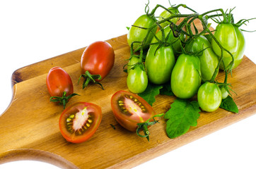 Branch of green unripe cherry tomatoes