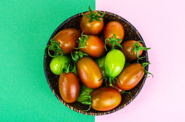 Wooden bowl with mature and immature tomatoes