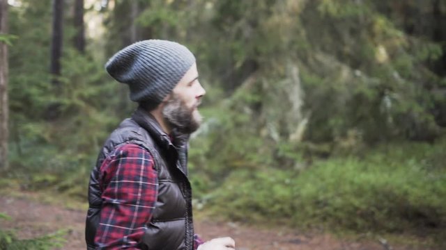 Outdoorsy photographer with a beard capturing a forest