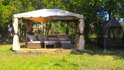 Picture of a gazebo with comfortable garden furniture.