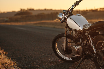 Naklejka premium Vintage motocykl na wiejskiej drodze
