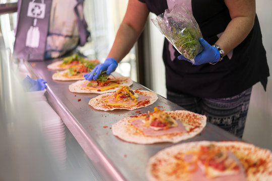 Woman in market stall filling tortilla wraps