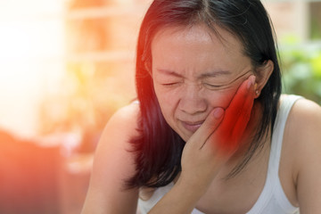 Temporomandibular Joint and Muscle Disorder: TMD concept. Woman hand on cheek face as suffering...