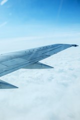 Fototapeta premium Airplane Wing Out of Window with Clouds and Sky