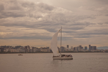 Sailboat returning to harbour at sunset with the city of Rio de Janeiro in the background